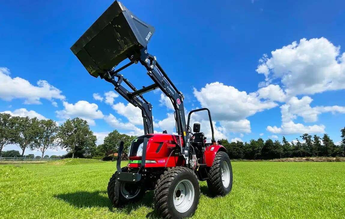 Elektrische tractor met voorlader op het gras
